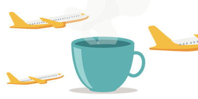 a cup of hot coffee with planes taking off in the background