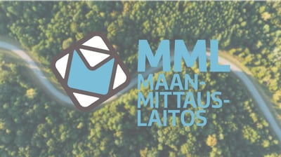 Maanmittauslaitoksen logo metsäisen ilmakuvan päällä