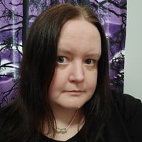 Heidi Koivisto, a Senior Software Developer at Eficode, with dark hair, wearing a black shirt with a purple curtain behind her.