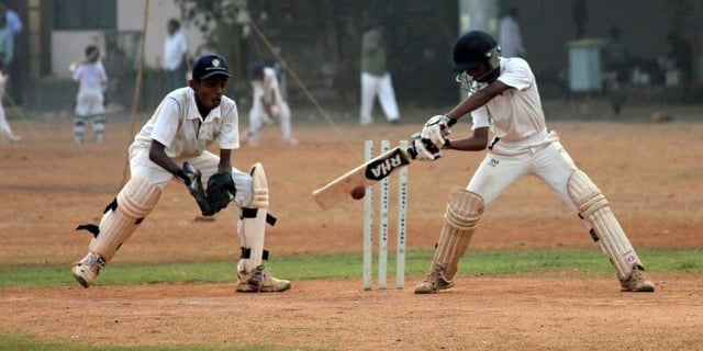 Two men playing cricket
