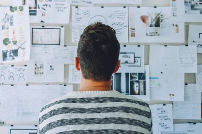 A man facing a wall full of ideas and notes