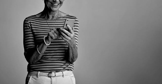 nainen käyttää matkapuhelinta harmaasävyisessä kuvassa